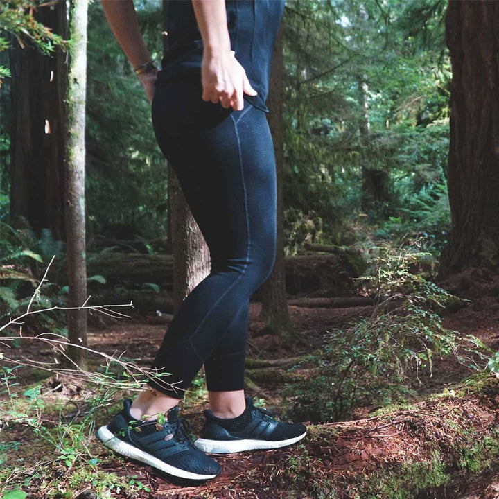 woman walking in the woods wearing minus33 heavyweight leggings
