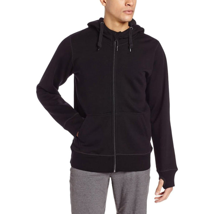 A man models the heavyweight brushed wool Kodiak Fleece Hoodie, crafted with thumbholes and a drawstring to bundle you up for wicked cold days! #color_black
