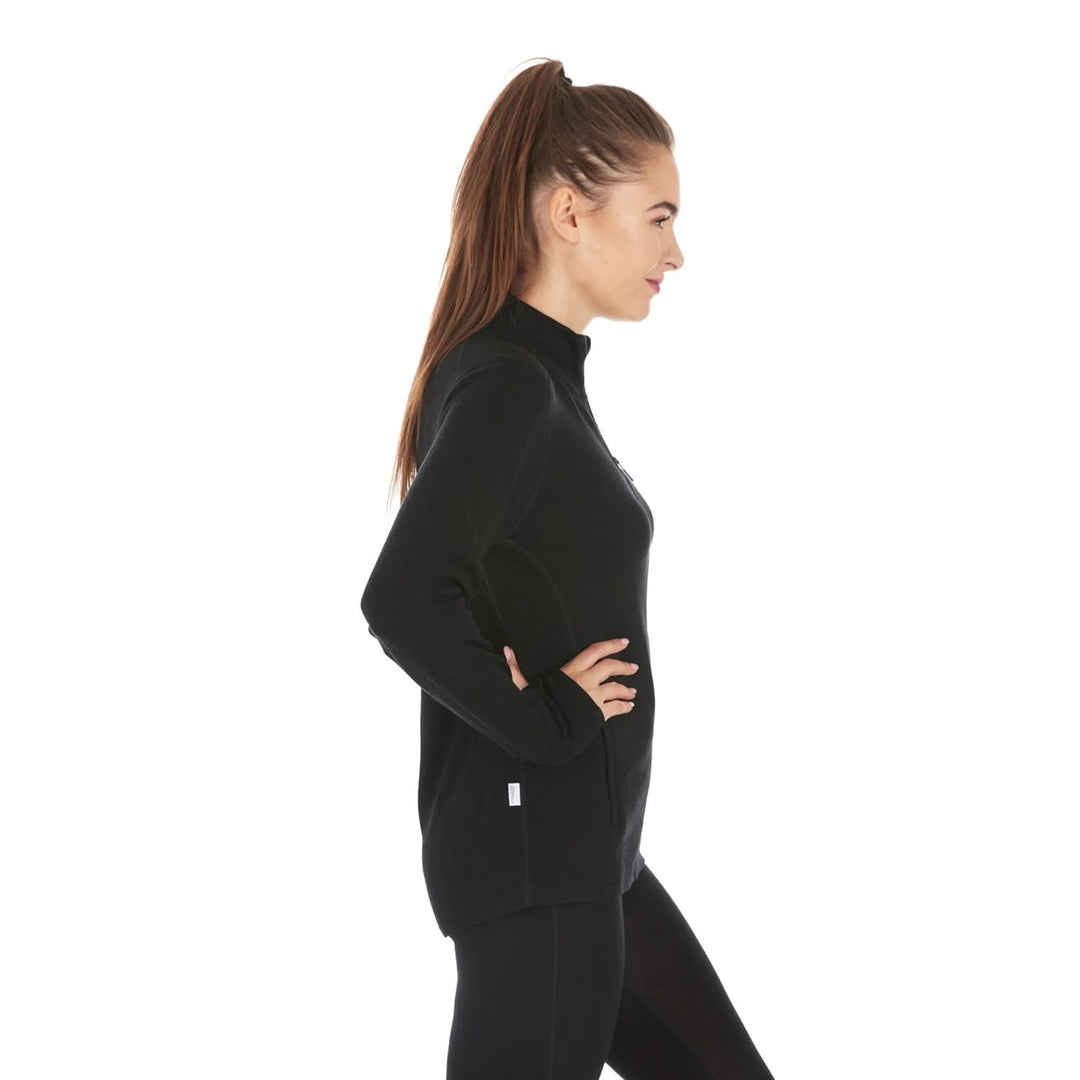 A woman models a hundred percent merino wool heavyweight full zip sweater. This outer layer features a two and a half inch mock neck collar, two zippered pockets, and thumbholes. #color_black