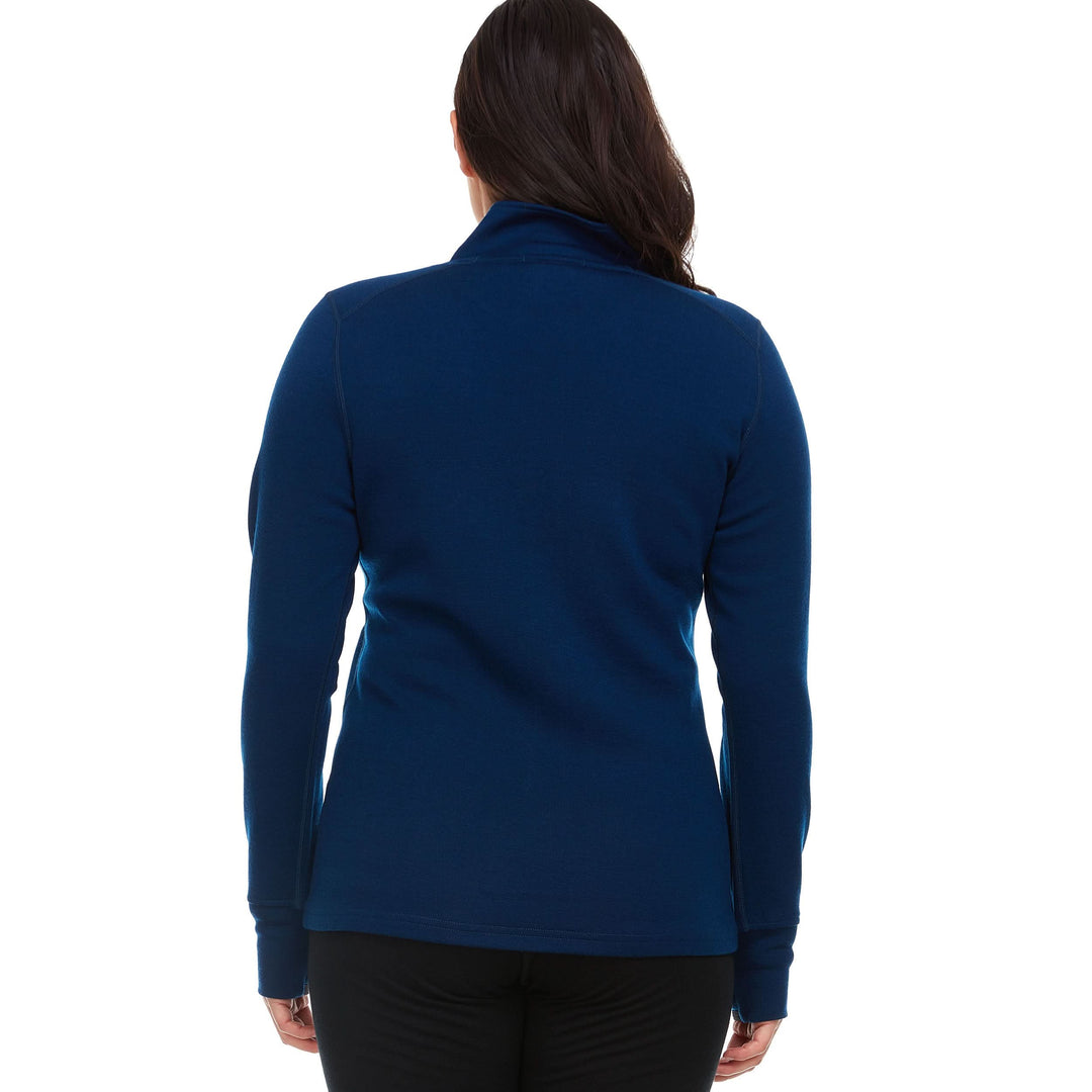 A woman models a hundred percent merino wool heavyweight full zip sweater. This outer layer features a two and a half inch mock neck collar, two zippered pockets, and thumbholes. #color_navy
