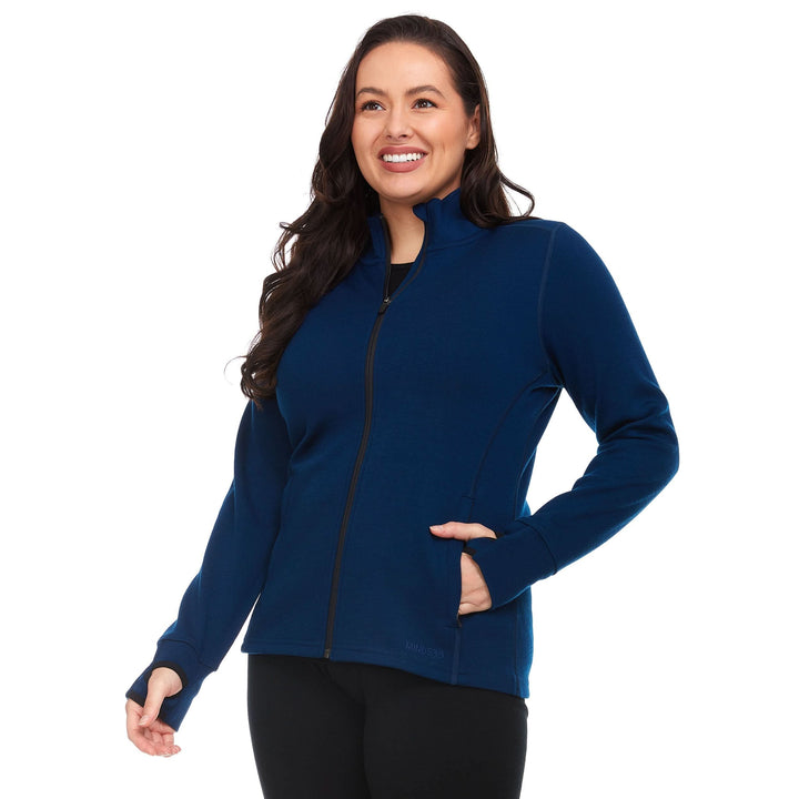 A woman models a hundred percent merino wool heavyweight full zip sweater. This outer layer features a two and a half inch mock neck collar, two zippered pockets, and thumbholes. #color_navy