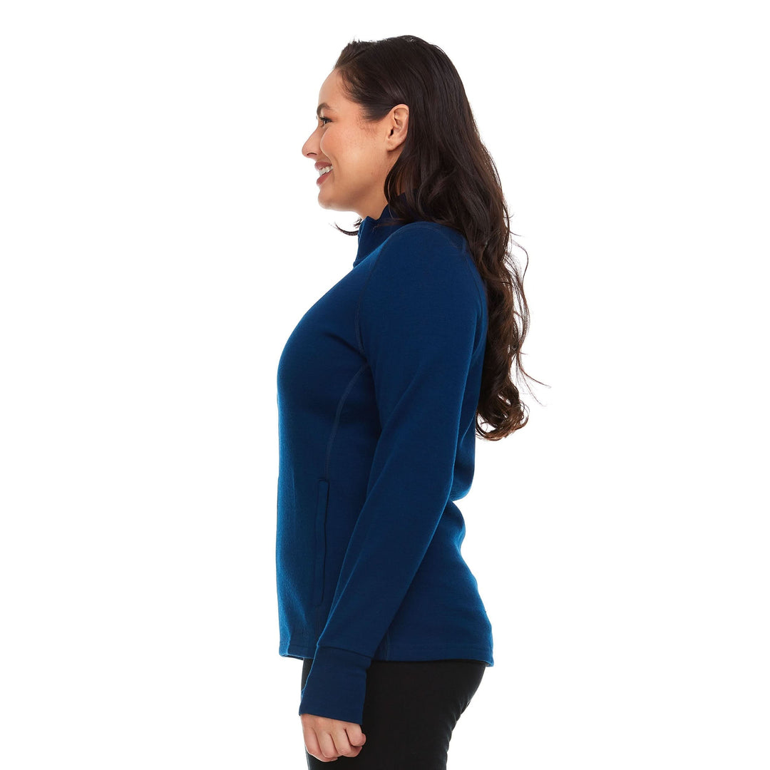 A woman models a hundred percent merino wool heavyweight full zip sweater. This outer layer features a two and a half inch mock neck collar, two zippered pockets, and thumbholes. #color_navy