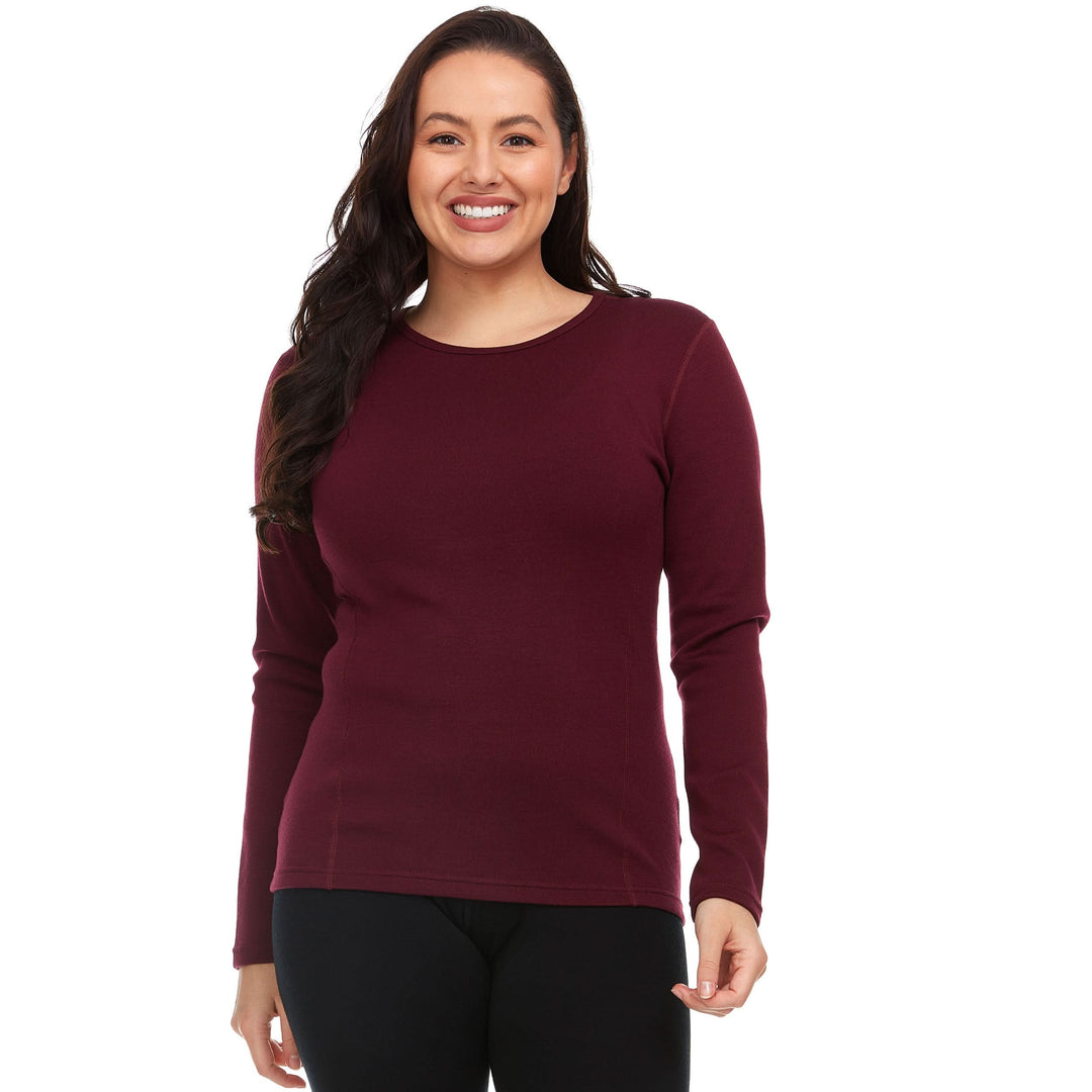 A woman models the one hundred percent merino wool heavyweight women's base layer crew top. This super soft top has a princess cut style for a more flattering fit. #color_burgundy
