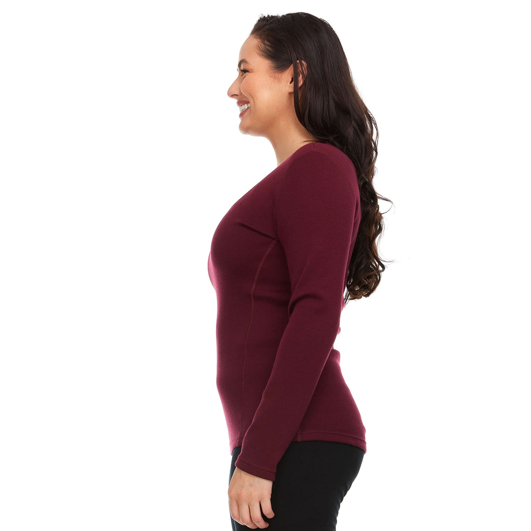 A woman models the one hundred percent merino wool heavyweight women's base layer crew top. This super soft top has a princess cut style for a more flattering fit. #color_burgundy