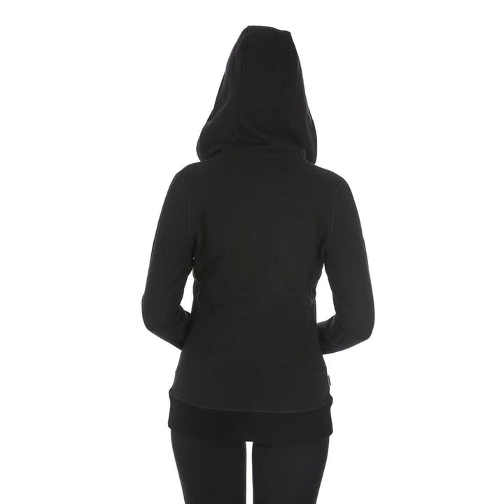 A woman models the heavyweight merino wool brushed fleece hoodie. The hoodie features a large hood with drawstrings, thumbholes, two pockets, and an interior stash pocket inside. #color_black