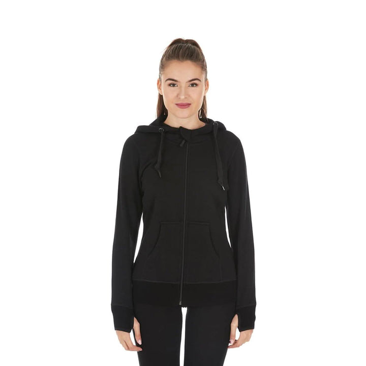 A woman models the heavyweight merino wool brushed fleece hoodie. The hoodie features a large hood with drawstrings, thumbholes, two pockets, and an interior stash pocket inside. #color_black