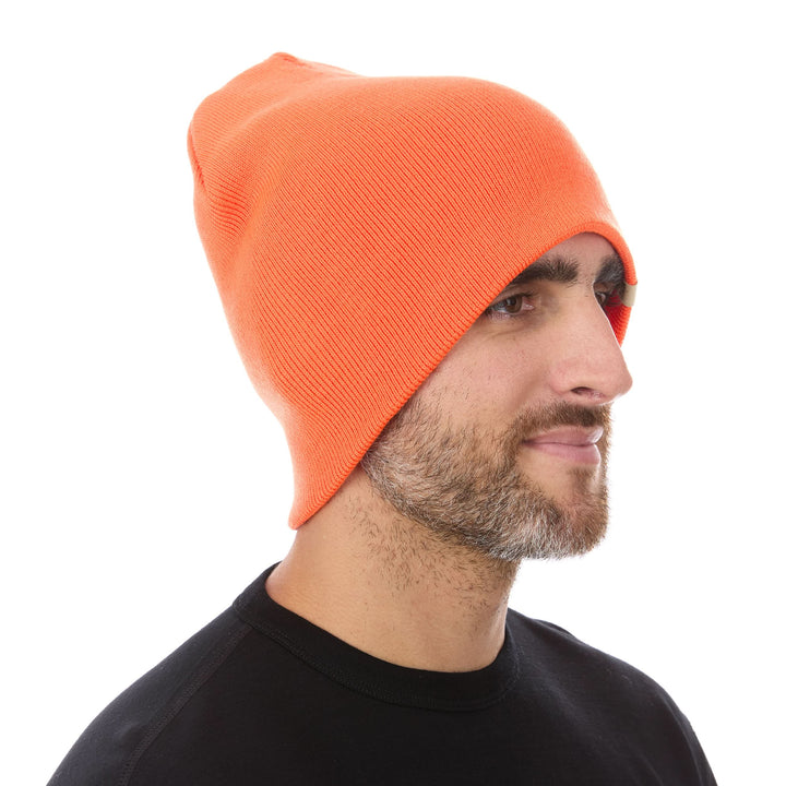 A man models a heavyweight, super soft, one hundred percent merino wool beanie. This heavyweight beanie is the warmest hat that we offer, perfect for hiking through the White Mountains, or sitting at a bonfire in January. #color_blaze-orange