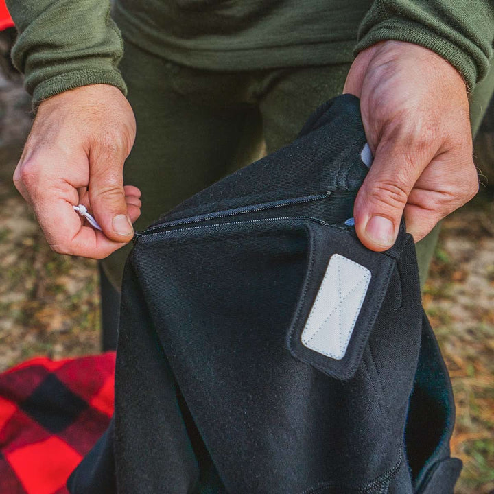 a guy showing that you can zip up these 100% merino wool bottoms