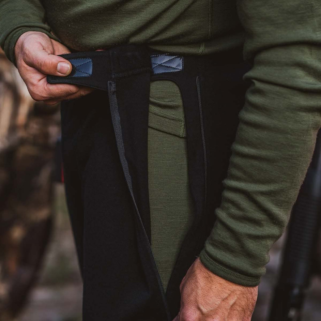 a guy zipping up his zip off pants as well as velcoring them on the side