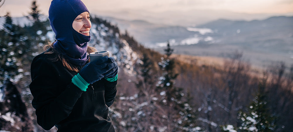 woman hiking on top of a mountain wearing wilderness expedition 1/4 zip