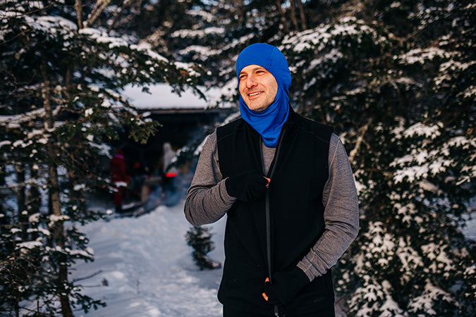 man wearing expedition weight heavyweight wilderness vest on a winter hike