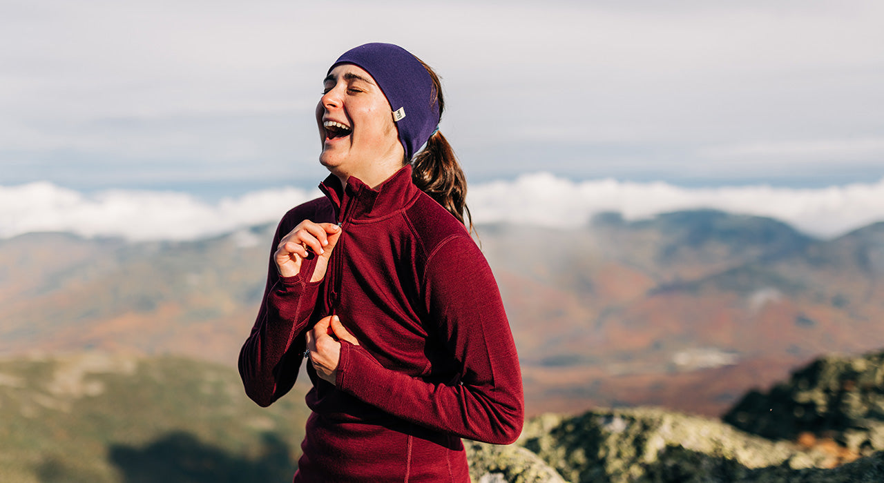 woman hiking wearing a 100% merino wool burgundy 1/4 zip