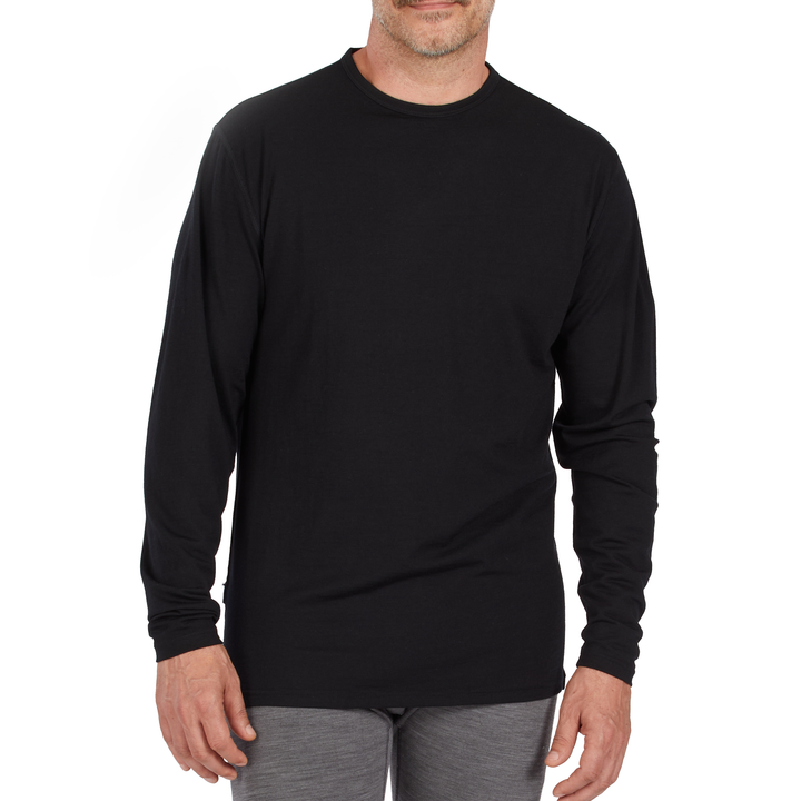 A man models the microweight long sleeved merino wool base layer crew neck top 