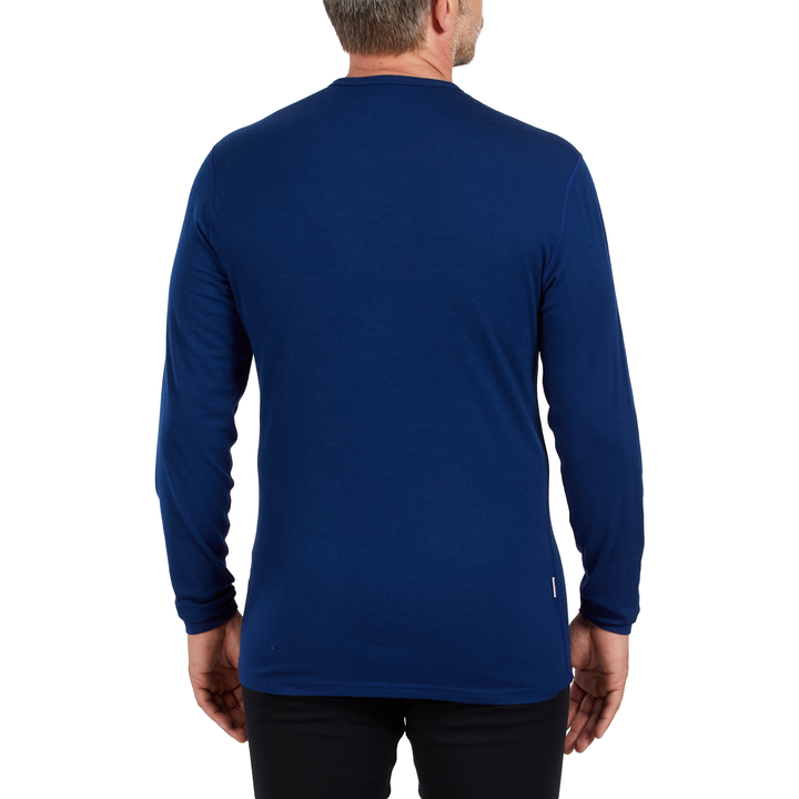 A man models the microweight long sleeved merino wool base layer crew neck top 