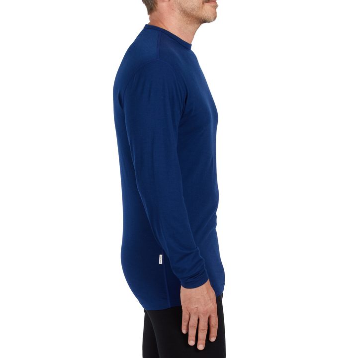 A man models the microweight long sleeved merino wool base layer crew neck top 