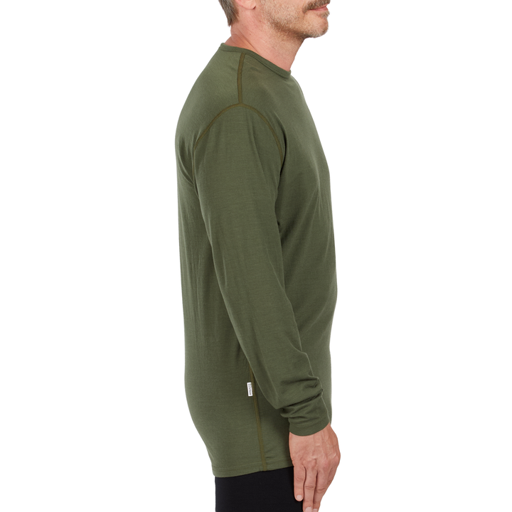A man models the microweight long sleeved merino wool base layer crew neck top 