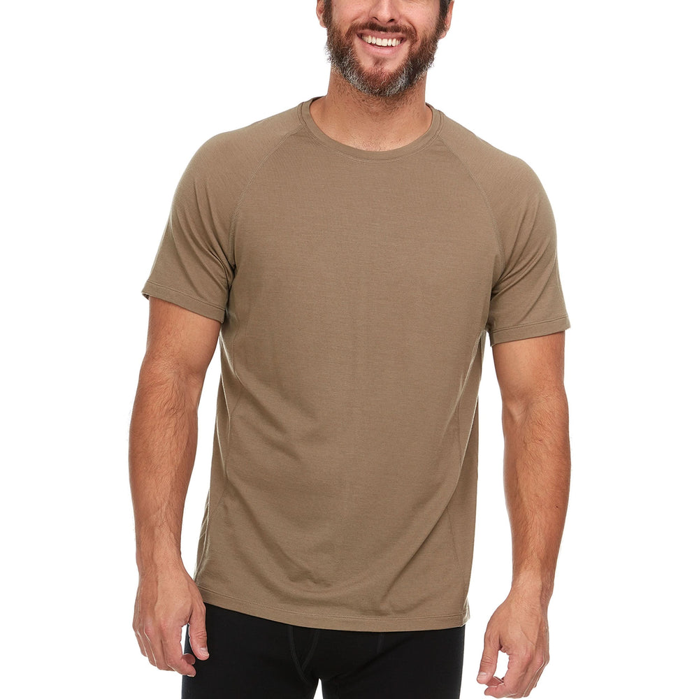 A man models the microweight Merino wool t shirt, your perfect choice for hitting the gym or setting foot on the trails. Raglan sleeves and side panels create a garment that moves with you #color_tan-499