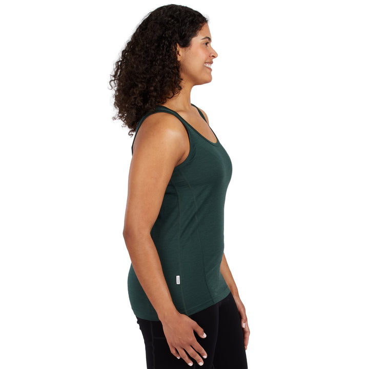 A woman with curly dark hair is shown in side profile wearing a dark green athletic tank top and black leggings against a plain white background. 