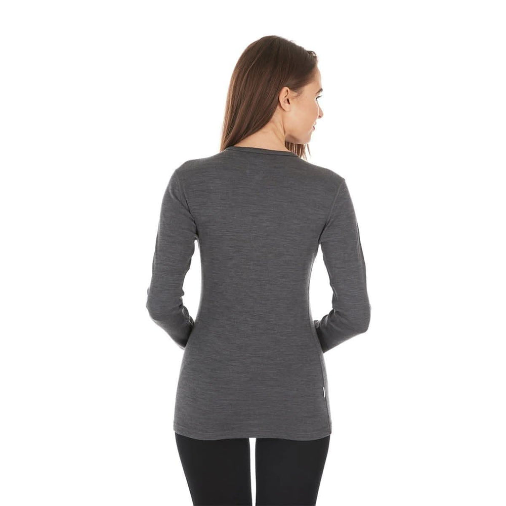 A woman models a soft, 100% merino wool, midweight base layer crew top. The women's midweight base layer crew features a princess cut for a more flattering fit #color_charcoal-gray
