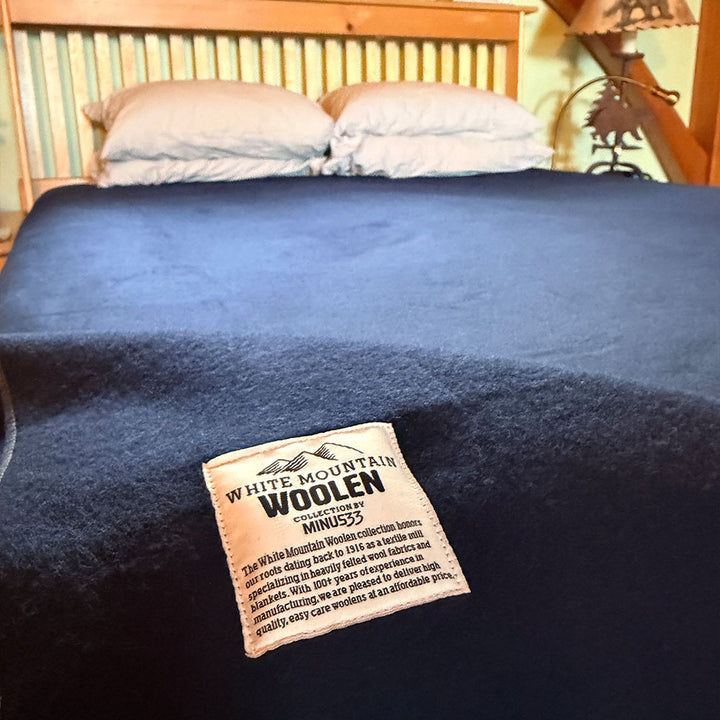 Blue wool king sized blanket on a bed with a &