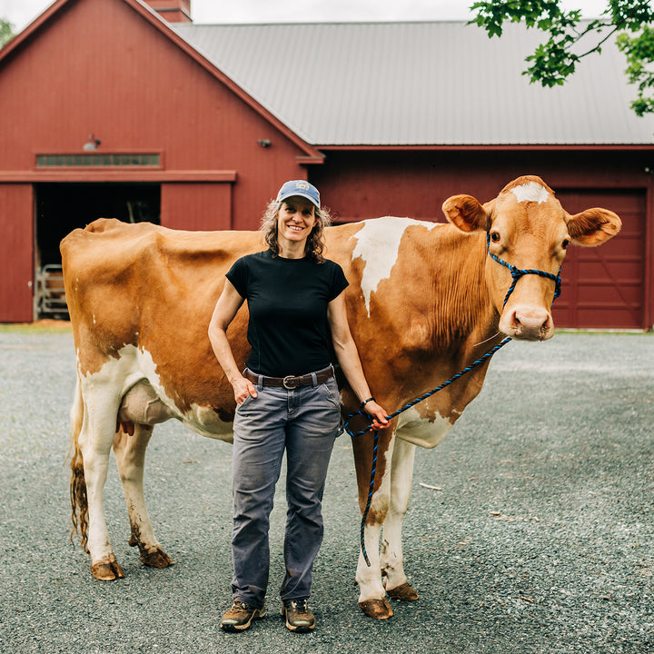 Woman wearing Merino crew stands with prize dairy cow #color_black