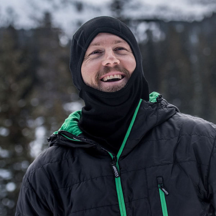 man wearing a black expedition weight balaclava while outside in the winter#color_black