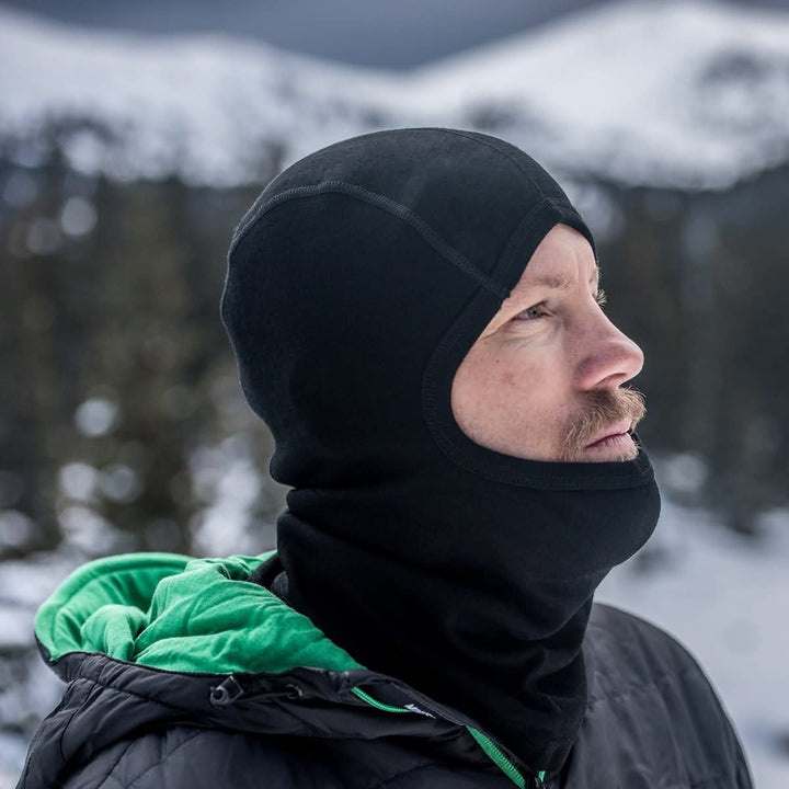 man wearing a black expedition weight balaclava while outside in the winter#color_black